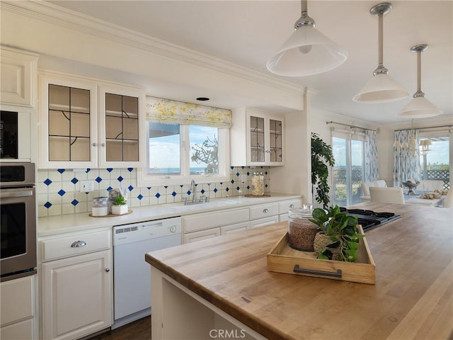 kitchen featuring dishwasher, oven, decorative light fixtures, and sink