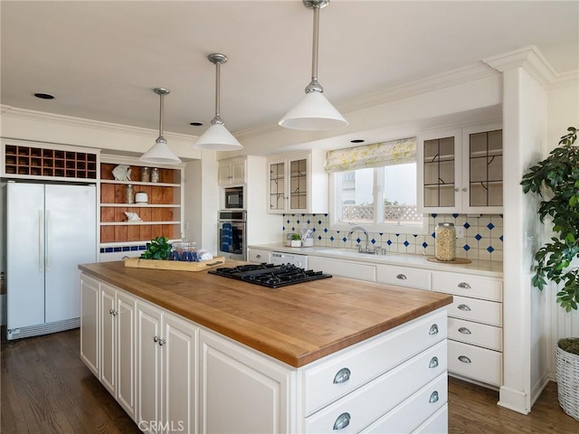 kitchen with a center island, white fridge, white cabinetry, and tasteful backsplash