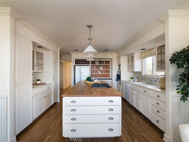 kitchen featuring white cabinets, a kitchen island, stainless steel appliances, and decorative light fixtures