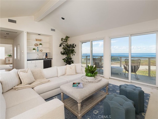 living room featuring vaulted ceiling with beams, a water view, bar, and a healthy amount of sunlight