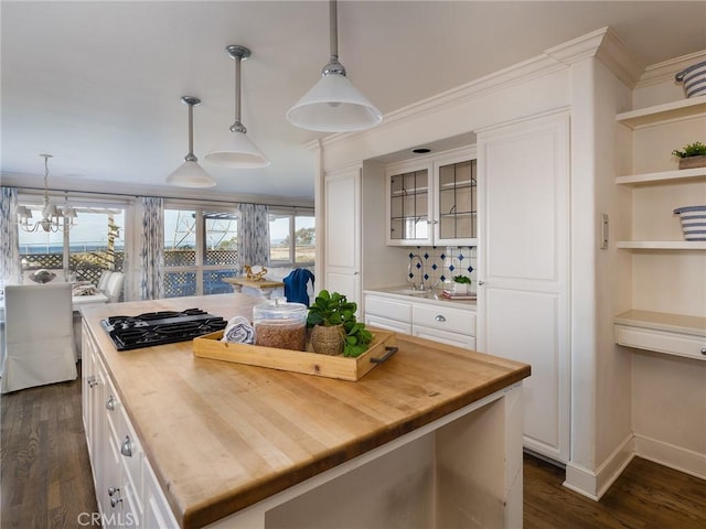 kitchen featuring pendant lighting, white cabinetry, a kitchen island, and butcher block counters