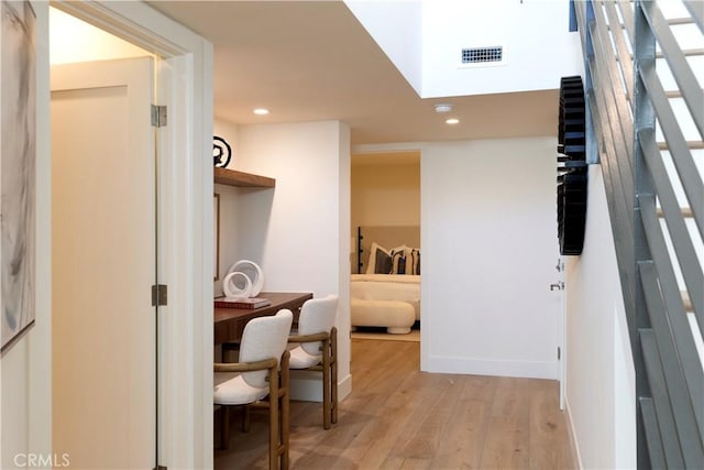 hall with light wood finished floors, visible vents, and recessed lighting