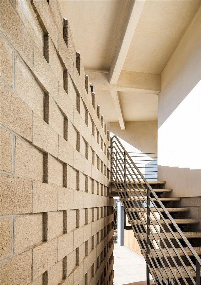 staircase with beamed ceiling