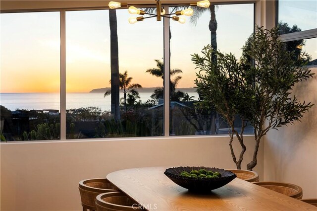 dining room featuring a notable chandelier and a water view