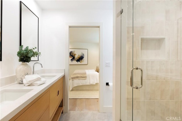 bathroom featuring double vanity, a shower stall, a sink, and ensuite bathroom