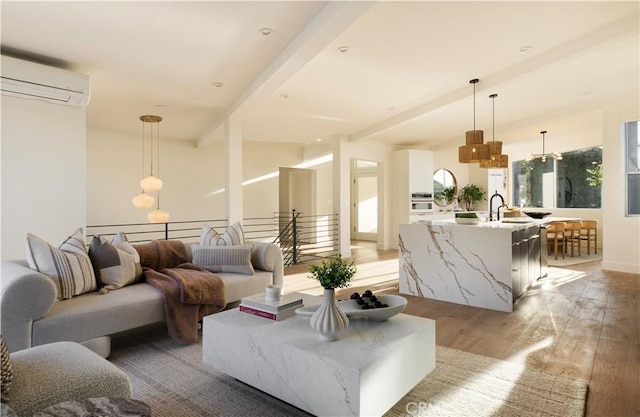 living room featuring lofted ceiling with beams, light wood-style flooring, and an AC wall unit