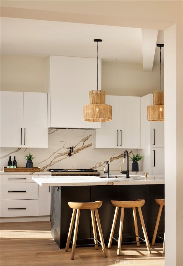 kitchen featuring light countertops, white cabinets, and a kitchen breakfast bar