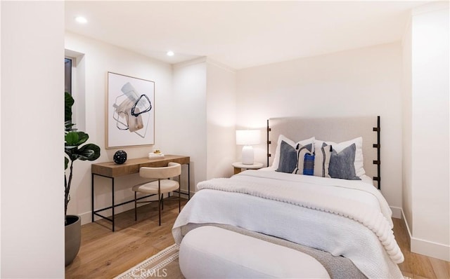 bedroom featuring baseboards, wood finished floors, and recessed lighting