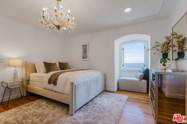 bedroom featuring a chandelier and light wood-type flooring