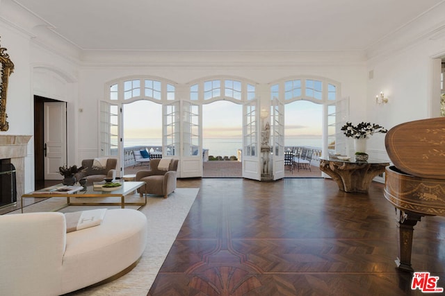 living room featuring dark parquet flooring, plenty of natural light, a tile fireplace, and ornamental molding