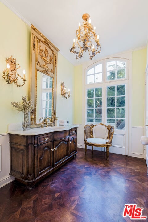 bathroom featuring vanity, ornamental molding, parquet floors, and an inviting chandelier