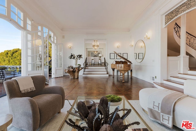 living room with dark parquet flooring, french doors, ornamental molding, and a notable chandelier