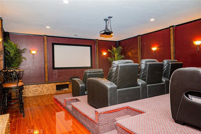 home theater with hardwood / wood-style floors and crown molding