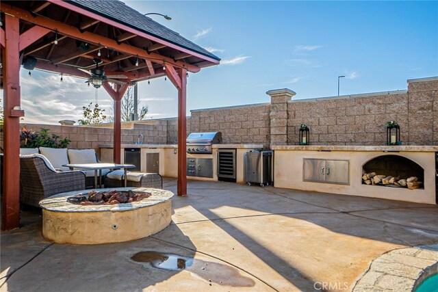 view of patio / terrace with beverage cooler, grilling area, an outdoor living space with a fire pit, a gazebo, and area for grilling