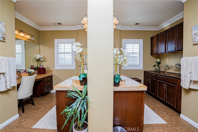 kitchen with light tile patterned floors, dark brown cabinetry, decorative light fixtures, and crown molding