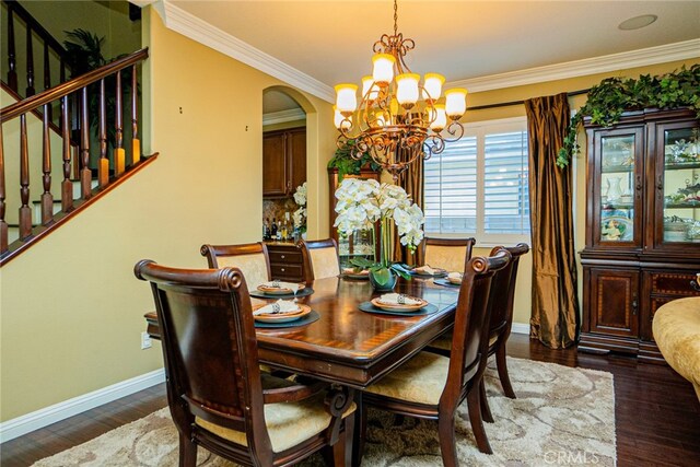 dining room featuring dark hardwood / wood-style flooring, an inviting chandelier, and ornamental molding