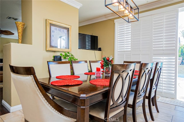 dining area with light tile patterned floors and crown molding