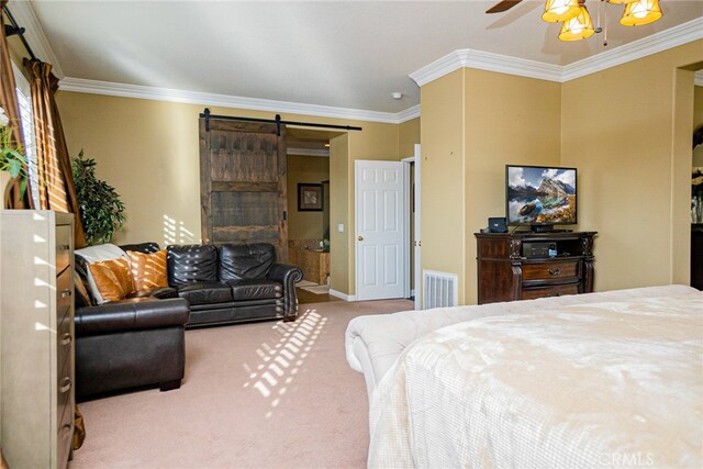 carpeted bedroom with a barn door, crown molding, and ceiling fan