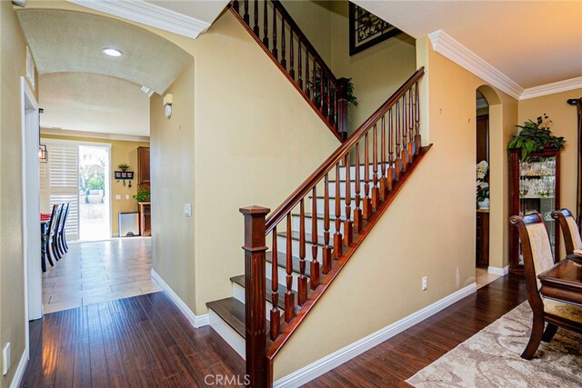 staircase featuring hardwood / wood-style flooring and ornamental molding