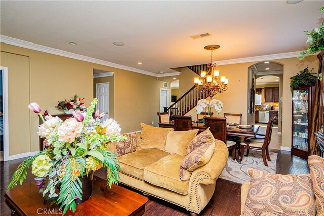 living room featuring a chandelier, wood-type flooring, and ornamental molding