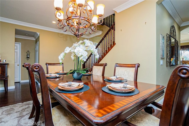 dining space with ornamental molding, a notable chandelier, and hardwood / wood-style flooring