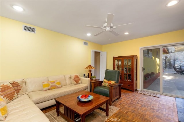 living room with dark parquet flooring and ceiling fan