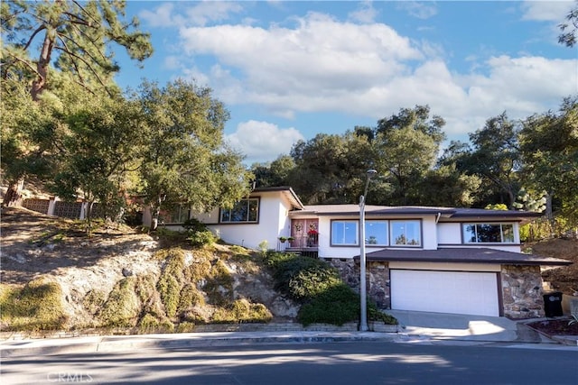 2541 Sleepy Hollow Dr, Glendale, CA 91206 - view of front facade with stone siding, stucco siding, driveway, and a garage