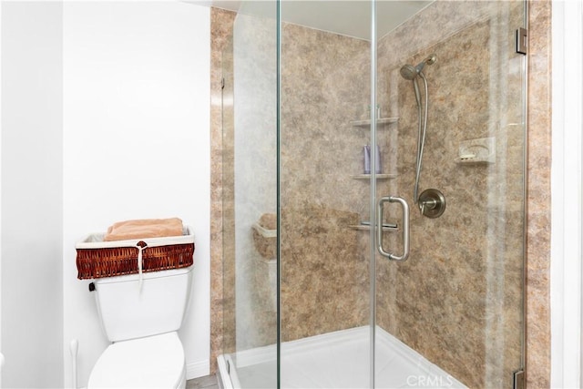 bathroom featuring toilet and an enclosed shower