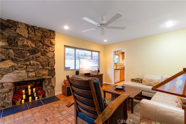 living room featuring ceiling fan, parquet flooring, and a fireplace