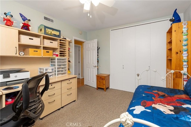 carpeted bedroom featuring ceiling fan and a closet