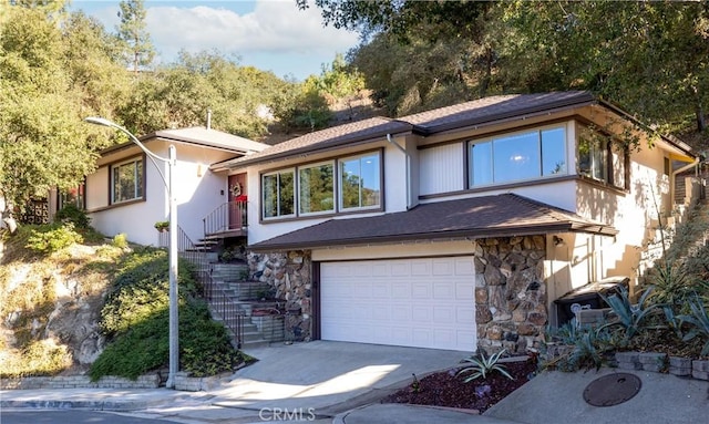 2541 Sleepy Hollow Dr, Glendale, CA 91206 - view of front of home featuring stone siding, an attached garage, driveway, and stairway