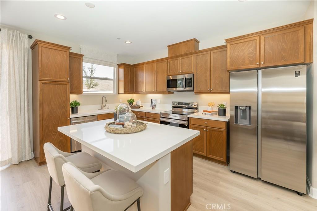 kitchen featuring a breakfast bar area, stainless steel appliances, a kitchen island with sink, light hardwood / wood-style flooring, and sink