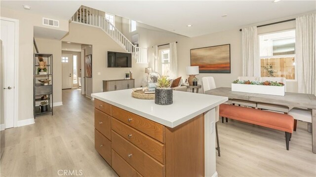 kitchen featuring light wood-type flooring, a kitchen bar, and a kitchen island