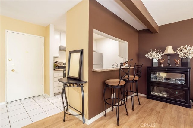 interior space featuring beamed ceiling and light hardwood / wood-style floors