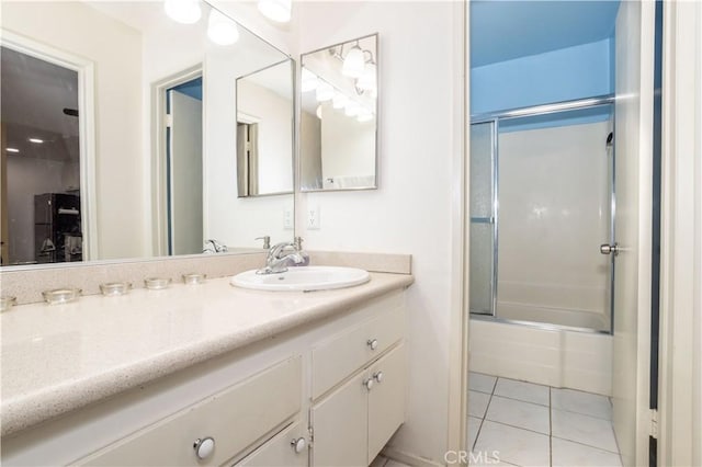 bathroom with tile patterned floors, vanity, and shower / bath combination with glass door