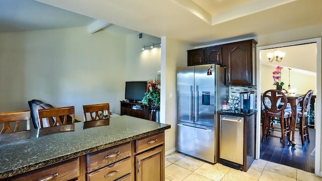 kitchen featuring dark stone counters, stainless steel refrigerator with ice dispenser, dark brown cabinets, light hardwood / wood-style floors, and a chandelier