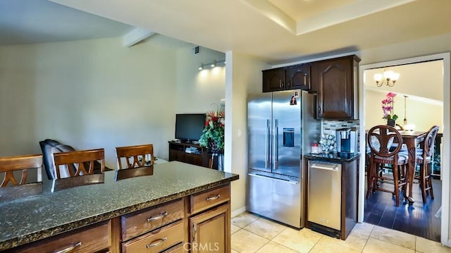 kitchen featuring dark stone counters, light hardwood / wood-style flooring, stainless steel fridge, a notable chandelier, and dark brown cabinetry