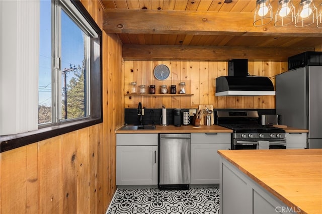 kitchen with sink, stainless steel appliances, beamed ceiling, ventilation hood, and white cabinets