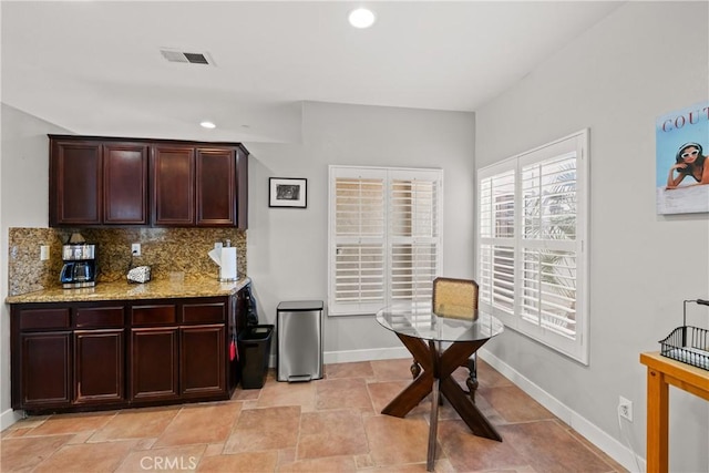 kitchen with light stone counters and decorative backsplash