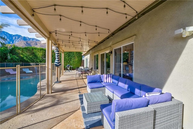 view of patio / terrace featuring a fenced in pool, an outdoor living space, and a mountain view