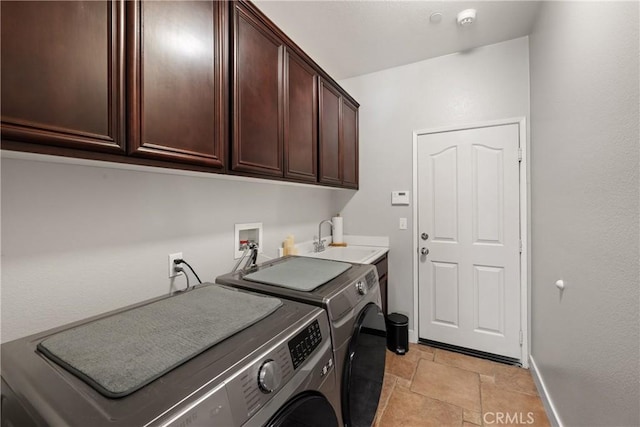 clothes washing area featuring washer and dryer, sink, and cabinets