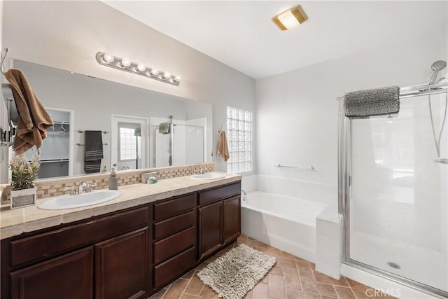 bathroom with vanity, decorative backsplash, plenty of natural light, and separate shower and tub