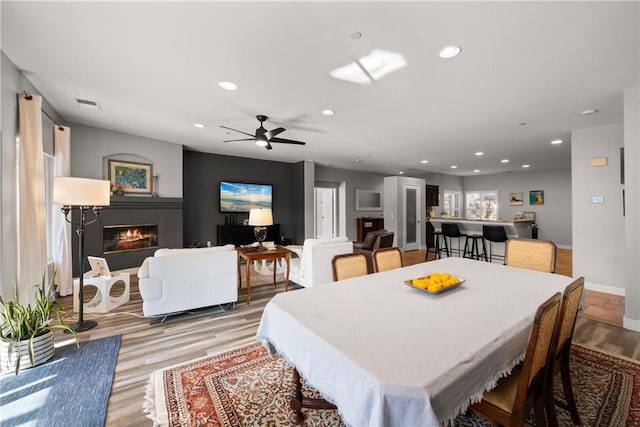 dining space with ceiling fan and light hardwood / wood-style flooring