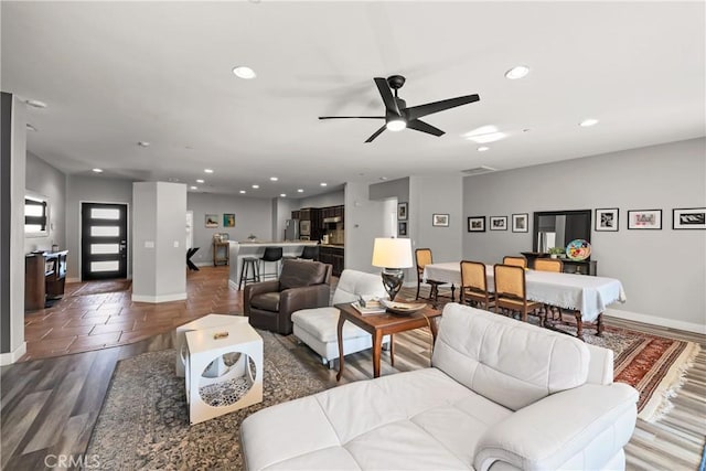 living room with dark wood-type flooring and ceiling fan