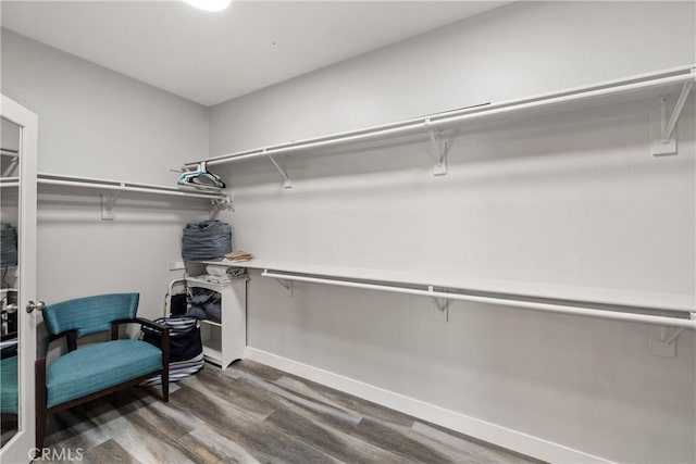 walk in closet with dark wood-type flooring