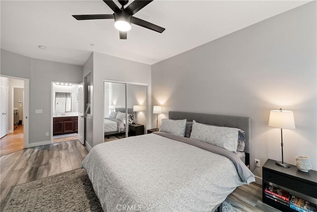 bedroom featuring wood-type flooring, connected bathroom, ceiling fan, and a closet