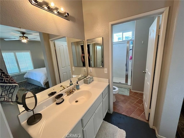 bathroom featuring ceiling fan, vanity, toilet, and a shower with shower door