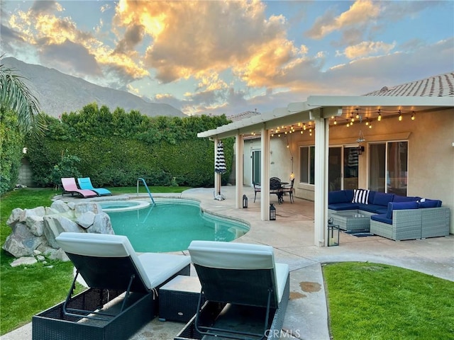 pool at dusk with an outdoor living space, an in ground hot tub, a mountain view, and a patio area