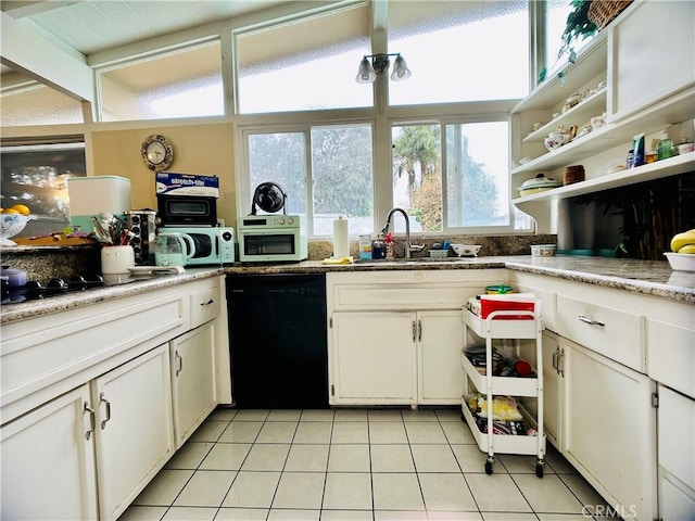 kitchen featuring light tile patterned floors, black dishwasher, white cabinetry, and sink