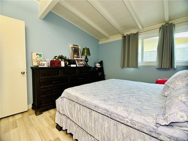 bedroom with vaulted ceiling with beams and light wood-type flooring